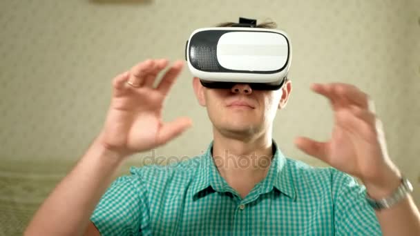 Мужчина в VR гарнитуре дома. Использование жестов руками
. - Кадры, видео