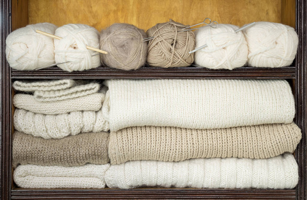 Scaffali riempiti da palline di lana, ferri da maglia, tessuti di lana pronti
 - Foto, immagini