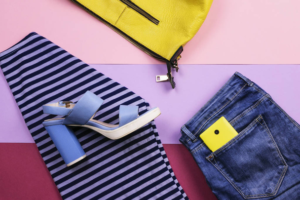 Bright women's accessories and clothing on a lilac background. The view from the top. Flat lay. - 写真・画像