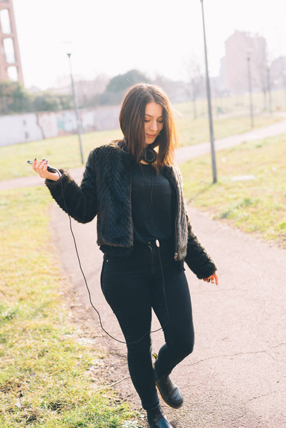 Genç güzel kadın smartphone kullanarak açık müzik dinleme - Fotoğraf, Görsel