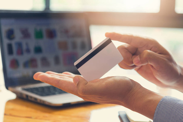 Empresário segurando cartão de crédito e usando laptop para fazer compras on-line
 - Foto, Imagem
