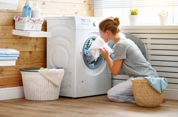 femme au foyer heureuse dans la buanderie avec lave-linge   - Photo, image
