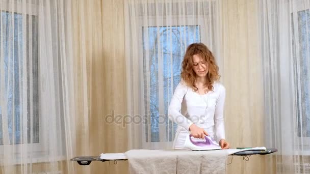 Funny and beautiful woman ironing clothes and dancing at home - Footage, Video