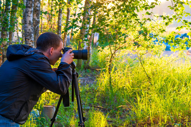 ein Mann mit Kamera auf Stativ fotografiert die Natur - Foto, Bild