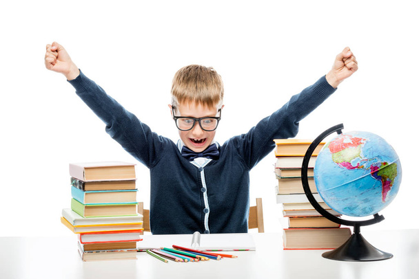 angry boy at table with books and globe against white background - Photo, Image