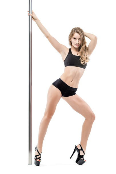 slender charming woman dancing near a pylon in sports underwear  - Foto, afbeelding