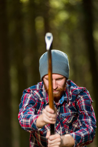 lumberjack chop wood with an ax in the woods - Zdjęcie, obraz