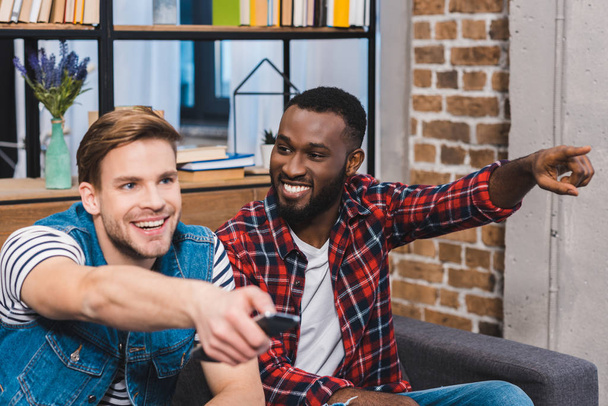 sorrindo jovens amigos multiétnicos assistindo tv juntos
 - Foto, Imagem