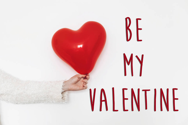 be my valentine text sign. happy valentine's day concept. hand holding  red heart balloon on white background with space for text. greeting card - Photo, Image