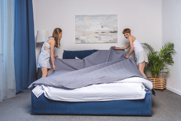 lesbisches Paar verdeckt Bett in der Früh - Foto, Bild