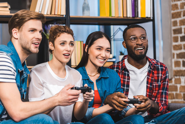 a joystick együtt otthon játszó fiatal többnemzetiségű meg  - Fotó, kép