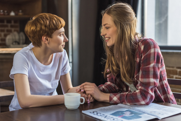 fiatal leszbikus pár beszélgetni, és a konyha a Kézenfogva - Fotó, kép