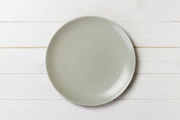 empty matte round plate on wood table. top view - Photo, Image