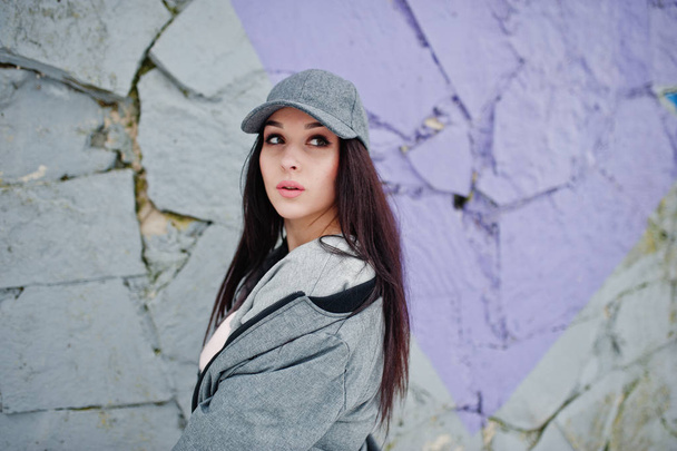 Stylish brunette girl in gray cap, casual street style on winter - 写真・画像