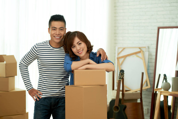 onnellinen aasialainen pari poseeraa kameralle, kun talo liikkuu
 - Valokuva, kuva