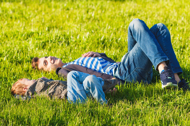 Two brothers, children and teenagers having fun, green meadow - Φωτογραφία, εικόνα