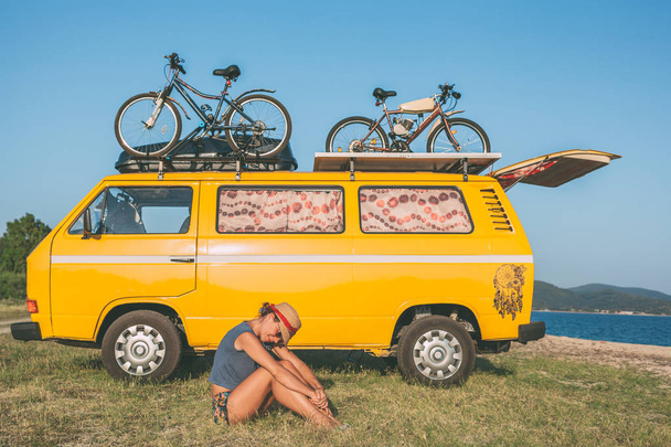 Nyár, nyaralás, közúti utazás, nyaralás, utazás, és az emberek koncepció - hippi fiatal nők, egyterű autó, a strand előtt - Fotó, kép