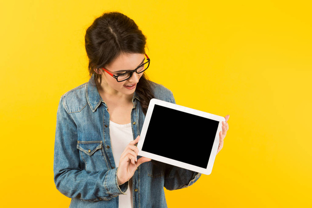 Nuori brunette nainen osoittaa digitaalinen tabletti tyhjä näyttö
 - Valokuva, kuva