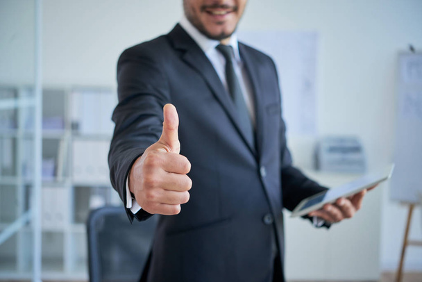 businessman gesturing thumbs up and holding digital tablet  - 写真・画像