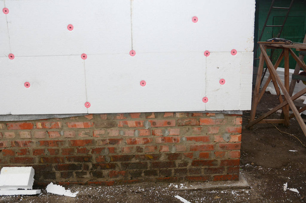 Renovação da parede da casa com isolamento rígido externo da placa de isopor ao ar livre para economia de energia
. - Foto, Imagem