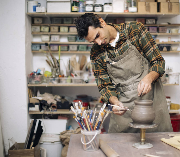 Giovane uomo che fa ceramica in laboratorio
 - Foto, immagini