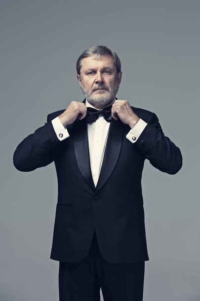 Middle aged male adult wearing a suit isolated on gray - Foto, Imagem