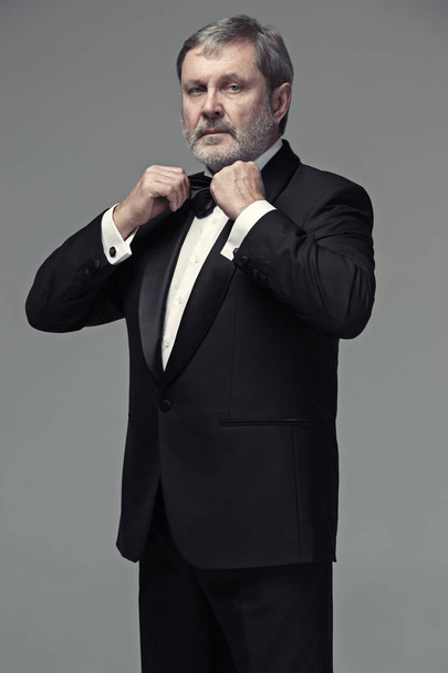 Middle aged male adult wearing a suit isolated on gray - Photo, Image