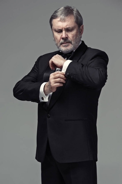 Middle aged male adult wearing a suit isolated on gray - Foto, immagini