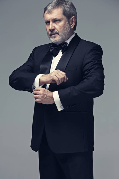 Middle aged male adult wearing a suit isolated on gray - Foto, afbeelding