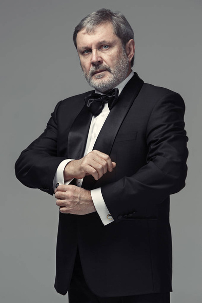 Middle aged male adult wearing a suit isolated on gray - Photo, Image