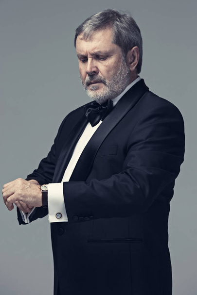 Middle aged male adult wearing a suit isolated on gray - Foto, immagini