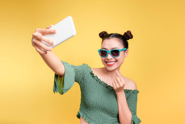 junge fröhliche attraktive asiatische Frau macht Selfie mit einem Lächeln - Foto, Bild
