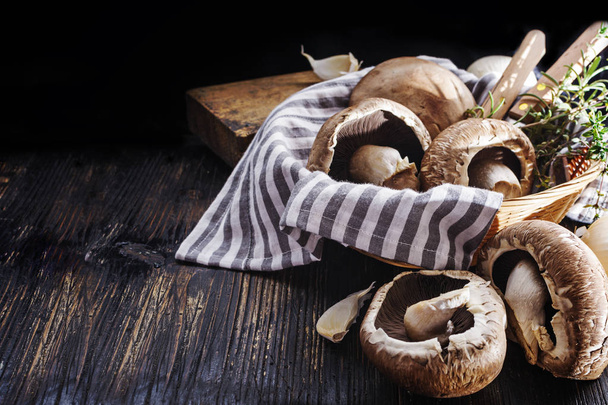 portobello mushrooms with  herbs in bowl on black wooden table - Zdjęcie, obraz