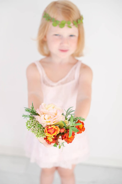 Red-haired girl in a pink dress is holding a bouquet - Foto, Imagen