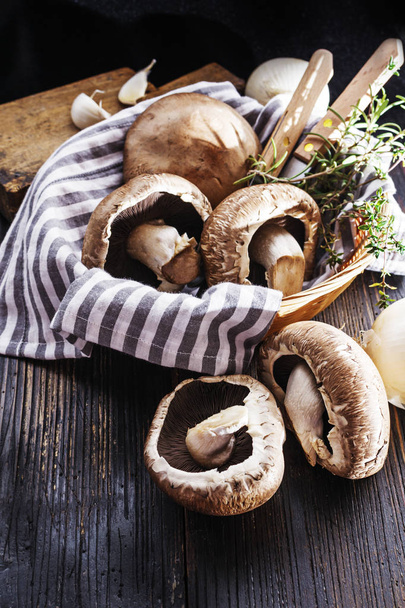 portobello mushrooms with  herbs in bowl on black wooden table - Foto, immagini