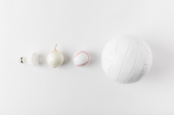 различное спортивное оборудование и лук в ряд на белой поверхности
 - Фото, изображение