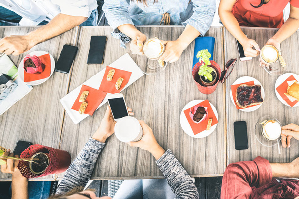 Vista superior de los amigos que beben cappuccino en el restaurante cafetería - La gente se divierten juntos comiendo pasteles y el uso de teléfonos inteligentes móviles en el bar cafetería - Concepto de amistad en el filtro azul brillante
 - Foto, Imagen
