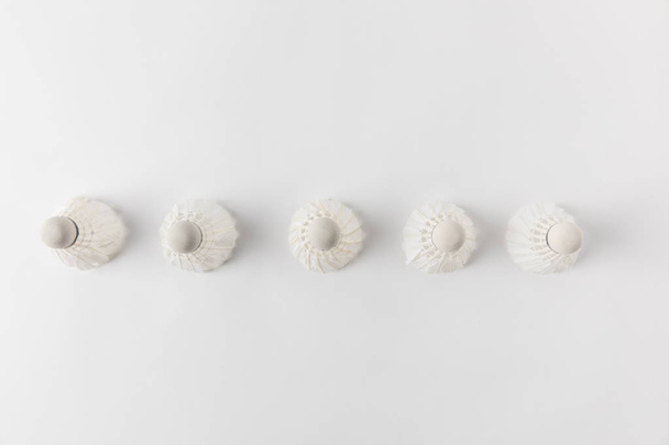 top view of badminton shuttlecocks in row on white surface - Photo, Image