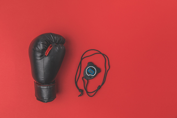 top view of boxing glove with stopwatch on red tabletop - Photo, Image