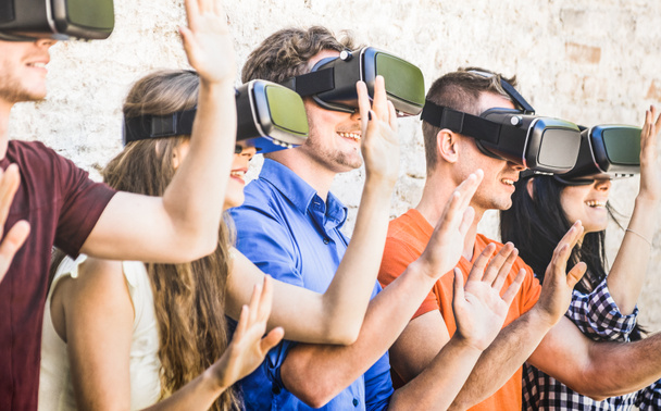 Groupe d'amis jouant sur des lunettes vr à l'extérieur - Réalité augmentée virtuelle et concept de technologie portable avec des jeunes s'amusant avec casque - Tendance de génération numérique - Filtre lumineux chaud
 - Photo, image