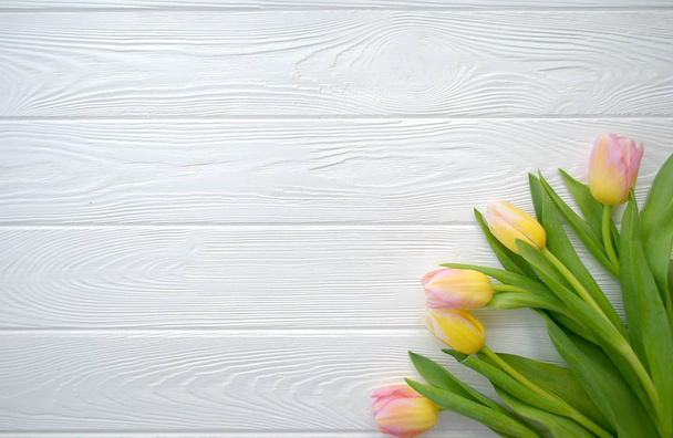 白い木製の背景に女性の日や母の日のはがきの素敵なチューリップの花。花春の背景コピー スペースに。フラットを置く. - 写真・画像