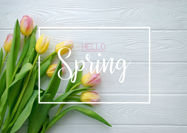 Ahoj jaro koncept. Krásný Tulipán květy na bílém pozadí dřevěná. Plochá ležel, horní pohled - Fotografie, Obrázek