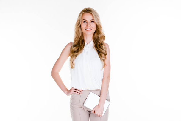 Ready for business meeting. Beautiful young woman holding her digital tablet and looking at camera with smile while standing against white background - Photo, image