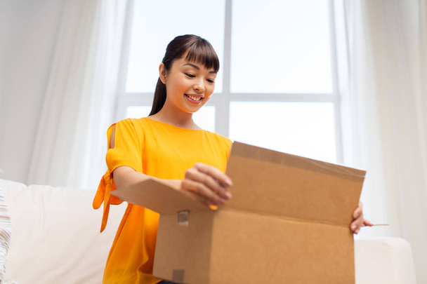 happy asian young woman with parcel box at home - Foto, immagini