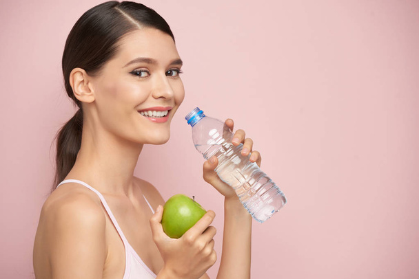 Zdravá mladá žena pít sladké vody, izolované na růžové - Fotografie, Obrázek