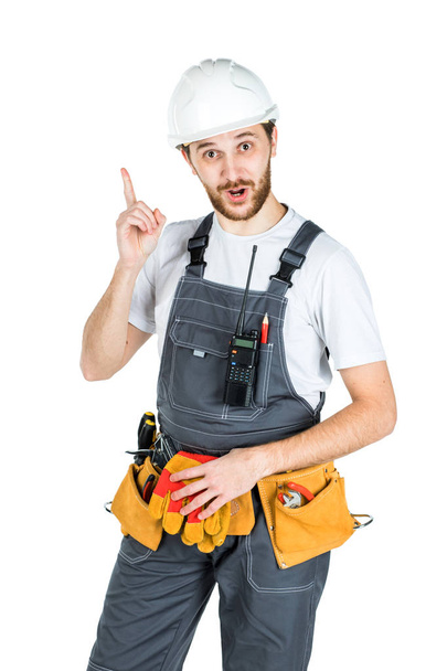 Будівельник або працівник в захисному шоломі, відображеному на тлі білої стіни
. - Фото, зображення