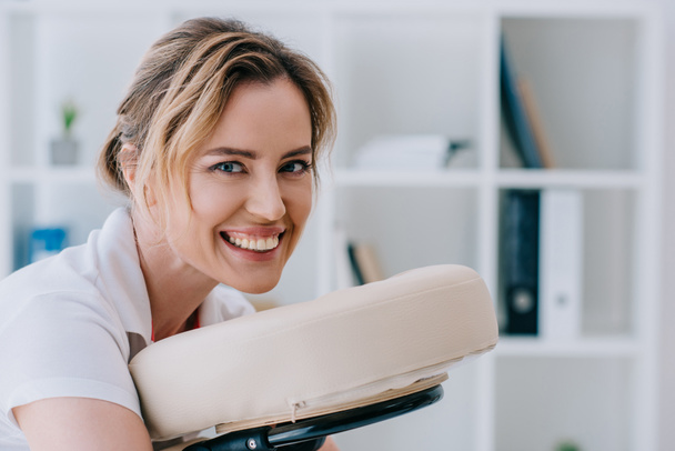 close-up portrait of attractive woman sitting on massage chair at office - Photo, Image