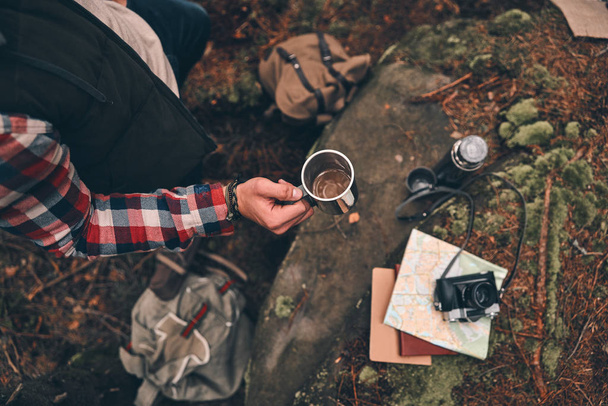 directly above shot of man holding mug while standing in forest - Photo, Image