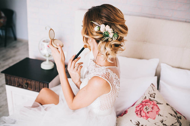 το πρωί της νύφης, το νύφη μοιάζει με ένα μικρό καθρέφτη, με τα λουλούδια στα μαλλιά της - Φωτογραφία, εικόνα