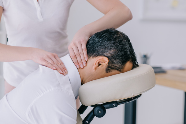 close-up shot of masseuse doing neck massage for businessman - Фото, изображение